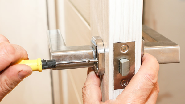 locksmith fitting lock on a door handle